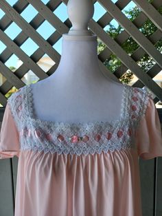 "A really sweet pale pink, soft nylon nightgown by Vanity Fair. Features white lace trim under the neckline interspersed with pink ribbon and a pink ribbon rose decorating the center. Cap sleeves, and a lovely flowy skirt. The fabric is smooth and soft, and semi-sheer.  Bust - 44\" (111 cm) Waist - 52\" (132 cm) Hips - Open Length - 34\" (86 cm) Sleeves - 7\" (17 cm) Condition -Very Good. Just a bit wrinkled from storage and a few picks in the nylon. I estimate this to fit a modern size Medium to Large. There is a bit of extra stretch/give in the fabric, but I did not take it into account when measuring. If you would like to measurement when stretched, please let me know." Pink Nightgown With Lace Trim For Bedtime, Pink Lace Trim Nightgown For Loungewear, Pink Delicate Lace Sleepwear For Summer, Coquette Nightgown With Lace Trim, Feminine Pink Sleepwear With Delicate Lace, Pink Delicate Lace Sleepwear, Feminine Pink Sleepwear With Lace Trim, Pink Feminine Sleepwear With Lace Trim, Pink Delicate Lace Nightgown For Sleep