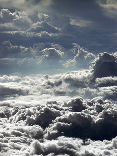 the sky is filled with lots of white clouds and some dark gray ones are in the foreground