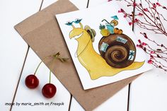 a card with a snail on it next to some cherries