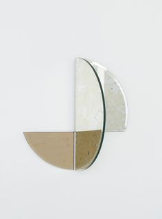 a circular mirror mounted to the side of a white wall next to a planter