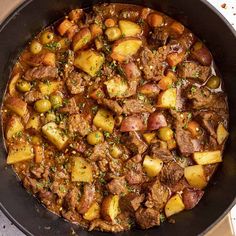 a pot filled with stew and potatoes on top of a table