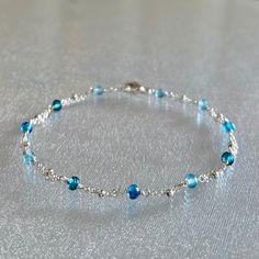 Super dainty mixed blue topaz gemstone beaded handmade bracelet in sterling silver This very thin and minimal bracelet is designed with genuine, 3.5 mm, sky blue topaz, london blue topaz and swiss blue topaz rondelles, evenly spaced along segments of double strand sterling silver chain and completed with a sterling silver lobster claw clasp.  These premium-quality gemstones are micro-faceted, highly polished, and quite sparkly.  Topaz is the birthstone for December. This skinny and dainty and bracelet is perfect for layering or worn by itself.  It is enlarged to show details.  Details: bracelet length: please choose at check-out faceted mixed blue topaz:  3.5 mm  sterling silver chain, clasp and other components Thanks for visiting ! Back to my shop for more jewelry options: www.etsy.com/s Minimal Bracelet, Topaz Bracelet, Blue Topaz Bracelet, Bracelet Minimalist, Bracelet Blue, Bracelet Ideas, Sky Blue Topaz, Swiss Blue Topaz, Blue Jewelry