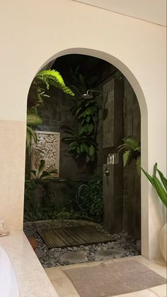 a bathroom with an arched doorway leading to the outside