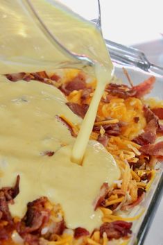 someone is pouring gravy on some food in a glass casserole dish