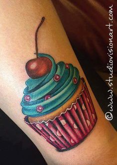 a cupcake tattoo with a cherry on the top and blue frosted icing