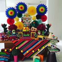 a table topped with lots of colorful decorations and paper flowers on top of it's sides