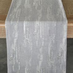 a wooden table topped with a silver cloth