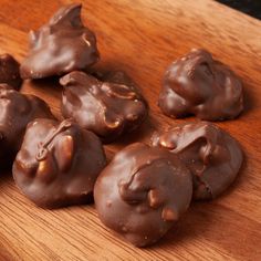 chocolate covered donuts sitting on top of a wooden cutting board