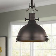 an industrial style pendant light hanging over a dining room table