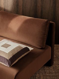 a brown couch with a pillow on top of it