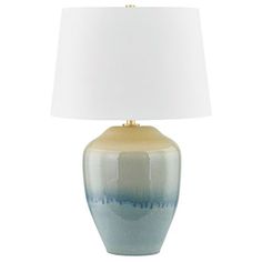 a blue and white lamp with a white shade on the top is sitting in front of a white background