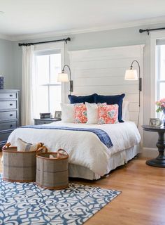 a bedroom with blue and white bedding, two lamps on either side of the bed