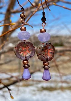 "Here's a beautiful pair of Lilac Hibiscus Flower Czech Glass earrings. The flower is lilac with a Picasso finish and a coral wash. It's 14mm with a lilac Czech glass teardrop that's 8x6mm. There's an Alexandrite Opal bead on top that's 4x7mm.  They dangle 1.5\" from a solid copper ear wire.  Beautiful earrings you'll love to wear or give as gifts.  So pretty for spring and summer." Hypoallergenic Purple Bohemian Earrings, Purple Flower Bohemian Earrings, Bohemian Purple Flower Earrings, Lavender Flower Jewelry With Matching Earrings, Lavender Flower Jewelry For Pierced Ears, Lavender Flower Jewelry Set With Matching Earrings, Hypoallergenic Purple Flower Jewelry, Handmade Adjustable Lavender Earrings, Lavender Flower Earrings With Ear Wire