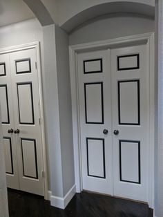 two white doors with black trim in a room