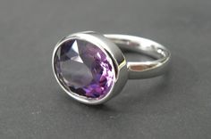 Minimalist amethyst ring in silver 925. The ring rail in omega shape was specially developed by me to allow transparent and translucent gemstones as much light incidence. The stone gets its full luminosity and intense colour. A ring for lovers of minimalist fine jewellery The ring has a stock size of US 7,25 - UK N 1/4 The ring size will be adjusted to the customer's size at no extra cost. When buying please note the desired size in the comment field. Amethyst 14x12mm - 6,66ct Silver 925, Sterli Modern Amethyst Ring With Polished Finish, Modern White Gold Amethyst Ring, Modern Sterling Silver Amethyst Ring With Polished Finish, Modern Sterling Silver Amethyst Ring For Formal Occasions, Modern Amethyst Ring With Bezel Setting, Modern Amethyst Ring As Gift, Modern White Gold Amethyst Ring As Gift, Modern White Gold Amethyst Ring Gift, Modern Purple Rings With Polished Finish