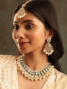 This jewellery set consists of a necklace, a pair of earrings and a maang tikkaGold-plated choker necklace has white kundan-studded and white beaded detailsSecured with a drawstring closureA pair of matching drop earrings, each secured with a post-and-back closureA matching maang tikka, secured with a hook closure Size & Fit Size : Necklace : 19 cmEarrings : 7 cmMaang Tikka : 21 cm Material & Care Material: BrassPlating: Gold-platedStone Type: Kundan and Artificial Beads Care Instructions Wipe your jewellery with a soft cloth after every useAlways store your jewellery in a flat box to avoid accidental scratchesKeep sprays and perfumes away from your jewelleryDo not soak your jewellery in water Dispatch within 7 days White Kundan Jewelry Sets, White Beaded Kundan Necklace For Diwali, White Kundan Necklace For Eid, Temple Jewelry Style, White Gota Work Jewelry, Beaded Kundan Chandbali Jewelry Sets, White Kundan Beaded Jewelry Sets, White Beaded Kundan Jewelry Sets, White Kundan Jewelry For Eid, White Beaded Kundan Bridal Necklace