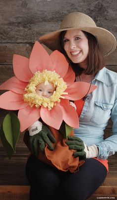 a woman sitting on a bench holding a fake flower