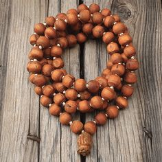 "📿Tulsi Mala handcrafted with Brown Tulsi beads. Suspended in the center is the engraved \"Krishna & Radha\" Guru Bead. When someone wears the tulsi mala, around your neck or around your wrist, you feel protected and focussed. It actually goes a long way in helping you deal with the stress of modern life.📿 🚪 Dimensions ( Approximately ) 🚪 📏Bead size: 11 MM - 12 MM 📏No. of beads: 108 Mala Bead + 1 Guru Bead 📏Mala Necklace Length: 50.0 - 51.0 inches 🚪 Pure Tulsi Beads Sourced from Vrindava Bohemian Mala With Large Beads For Meditation, Spiritual Necklace With 108 Natural Beads, Artisan Wooden Beads Bracelet For Meditation, Holistic Wooden Beads For Festivals, Spiritual Healing Beaded Necklaces With Large Beads, Meditation Jewelry With Wooden Round Beads, Meditation Jewelry With Round Wooden Beads, Holistic Mala With Round Beads For Festival, Spiritual Beaded Bracelet With Large Beads For Meditation