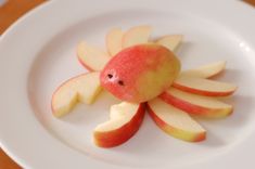 an apple shaped like a crab on a white plate