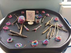 there is a tray with yarn and sticks on it