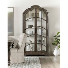 an old - fashioned china cabinet with glass doors is shown in this living room setting