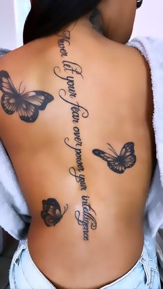 the back of a woman's body with butterflies on it and words written in cursive writing