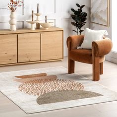 a living room area with a chair, rug and potted plant in the corner