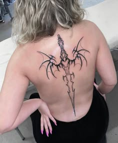 the back of a woman's body with tattoos on it