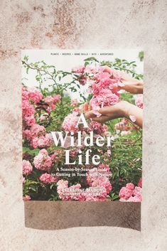 the cover of a book with pink flowers on it and hands reaching out to touch them