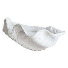 a white shell shaped bowl sitting on top of a table