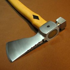 a yellow handled knife on top of a brown table