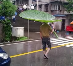 a man walking across a street holding an umbrella