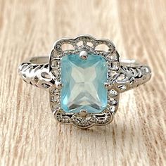 a ring with an aqua blue stone in the center and filigrees around it