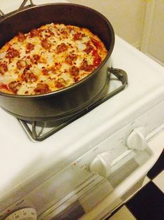 a pizza sitting in a pan on top of a stove