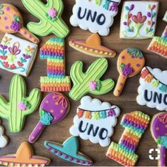 decorated cookies are arranged on a table with the word uno spelled in white letters and colorful decorations