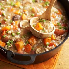 a wooden spoon in a pot filled with soup