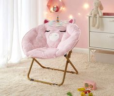 a child's rocking chair with a pink unicorn face on it in a bedroom