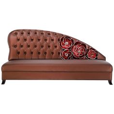 a brown leather couch with red roses on the armrests and back cushion, isolated against a white background