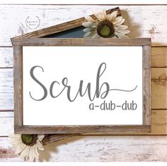 a wooden sign that says scrub, a - dubb and some daisies in front of it