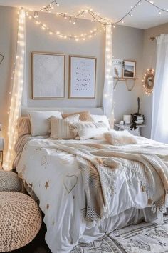 a bedroom decorated in white and gold with string lights