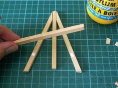 someone is making miniature wooden structures out of matchesticks