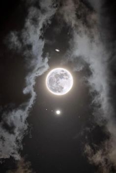 an image of the moon in the sky with clouds around it and two planets above