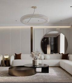 a living room with white couches and round coffee table