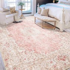 a bedroom with a large rug on the floor and a couch in front of it