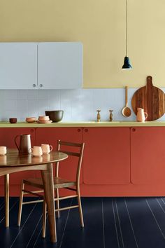 a kitchen with orange walls and wooden furniture