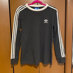 Never Worn. Adorable Long Sleeve Adidas Shirt With Stripes Along The Arms. Comes With Tags! Long Sleeve Tops With Three Stripes For Fall, Casual Long Sleeve Tops With Three Stripes, Adidas Long Sleeve Spring Tops, Adidas Long Sleeve Tops For Spring, Casual Three Stripes Tops For Fall, Fall Tops With Three Stripes, Black Long Sleeve Tops With Three Stripes Branding, Black Tops With Three Stripes For Spring, Adidas Long Sleeve Tops With Three Stripes