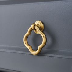 a close up of a door handle on a gray cabinet with a gold ring in the middle