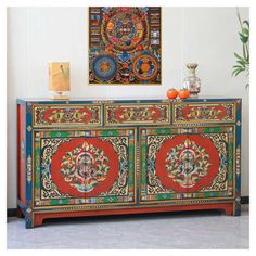 an ornately decorated sideboard in the corner of a room with a painting on the wall