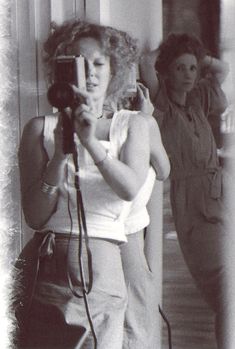 a woman is taking a selfie in front of a mirror while holding a hair dryer