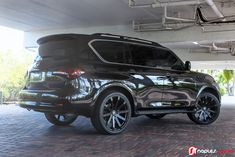 the back end of a black suv parked in a garage